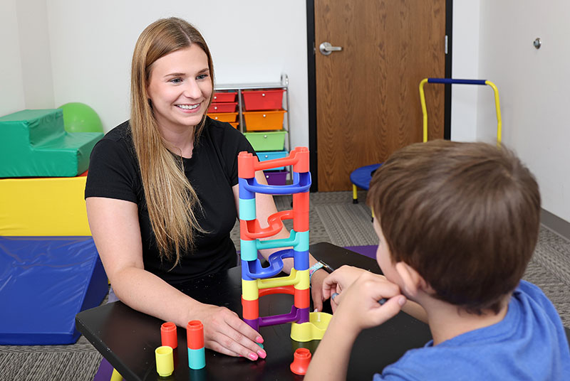 therapist and child working on fine motor skills by playing a game